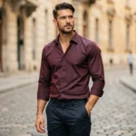 Homme élégant portant une chemise originale à motif géométrique bordeaux dans une rue pavée européenne